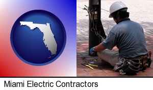 Miami, Florida - an electrician wearing a tool belt, installing electrical wiring