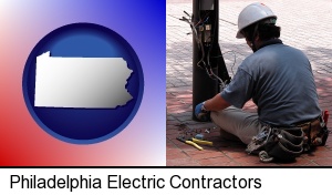 an electrician wearing a tool belt, installing electrical wiring in Philadelphia, PA
