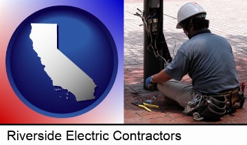 an electrician wearing a tool belt, installing electrical wiring in Riverside, CA