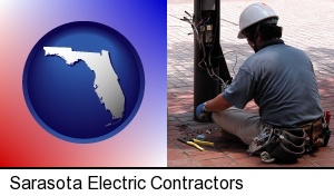 an electrician wearing a tool belt, installing electrical wiring in Sarasota, FL
