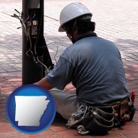 arkansas map icon and an electrician wearing a tool belt, installing electrical wiring