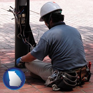 an electrician wearing a tool belt, installing electrical wiring - with Georgia icon